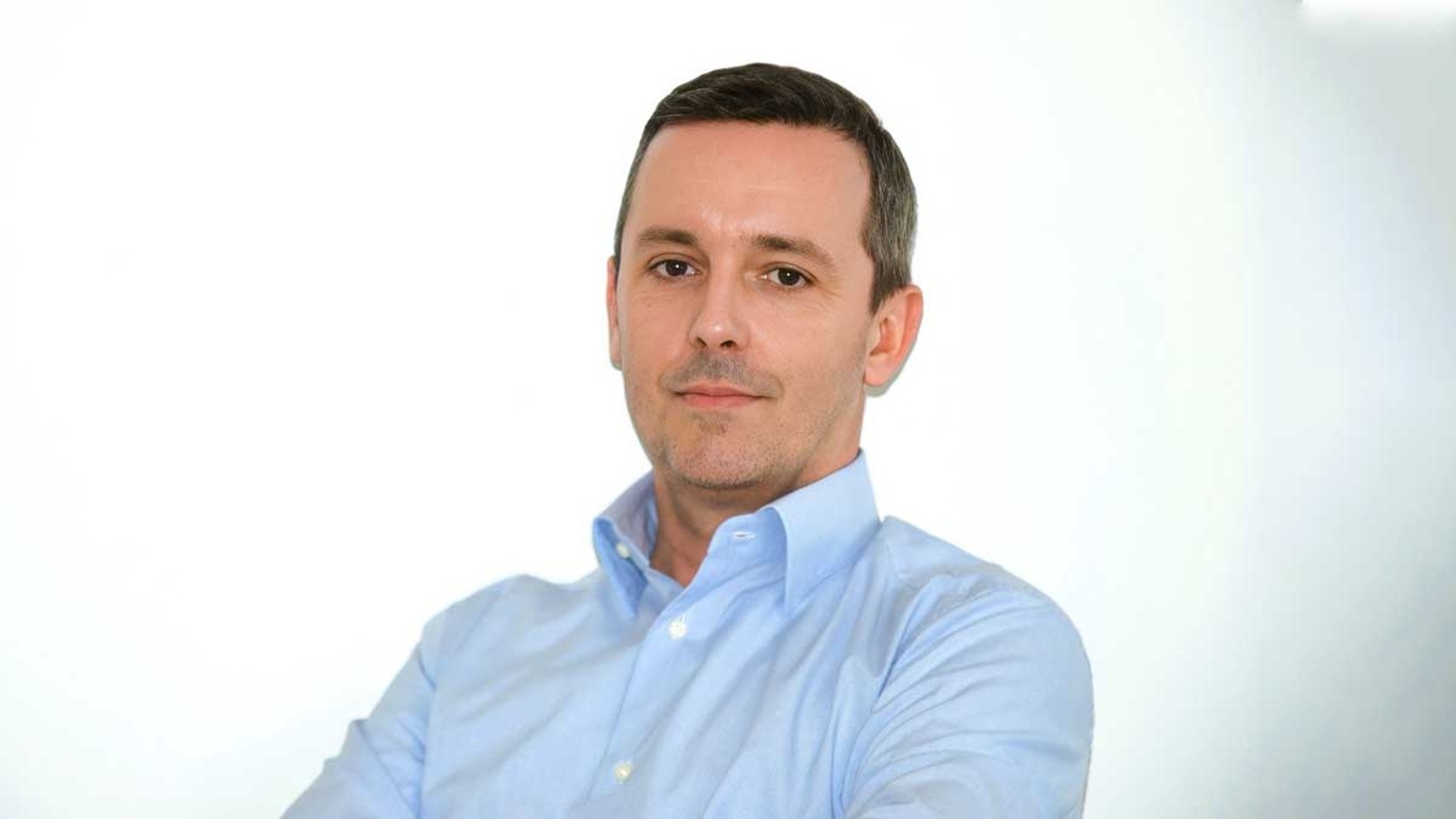 Pietro Casati, Founder & CEO of DAC SYSTEM SA, stands confidently in a light blue shirt against a bright, neutral background, his calm and composed expression reflecting the innovative solutions and products he plans to showcase at PMRExpo.